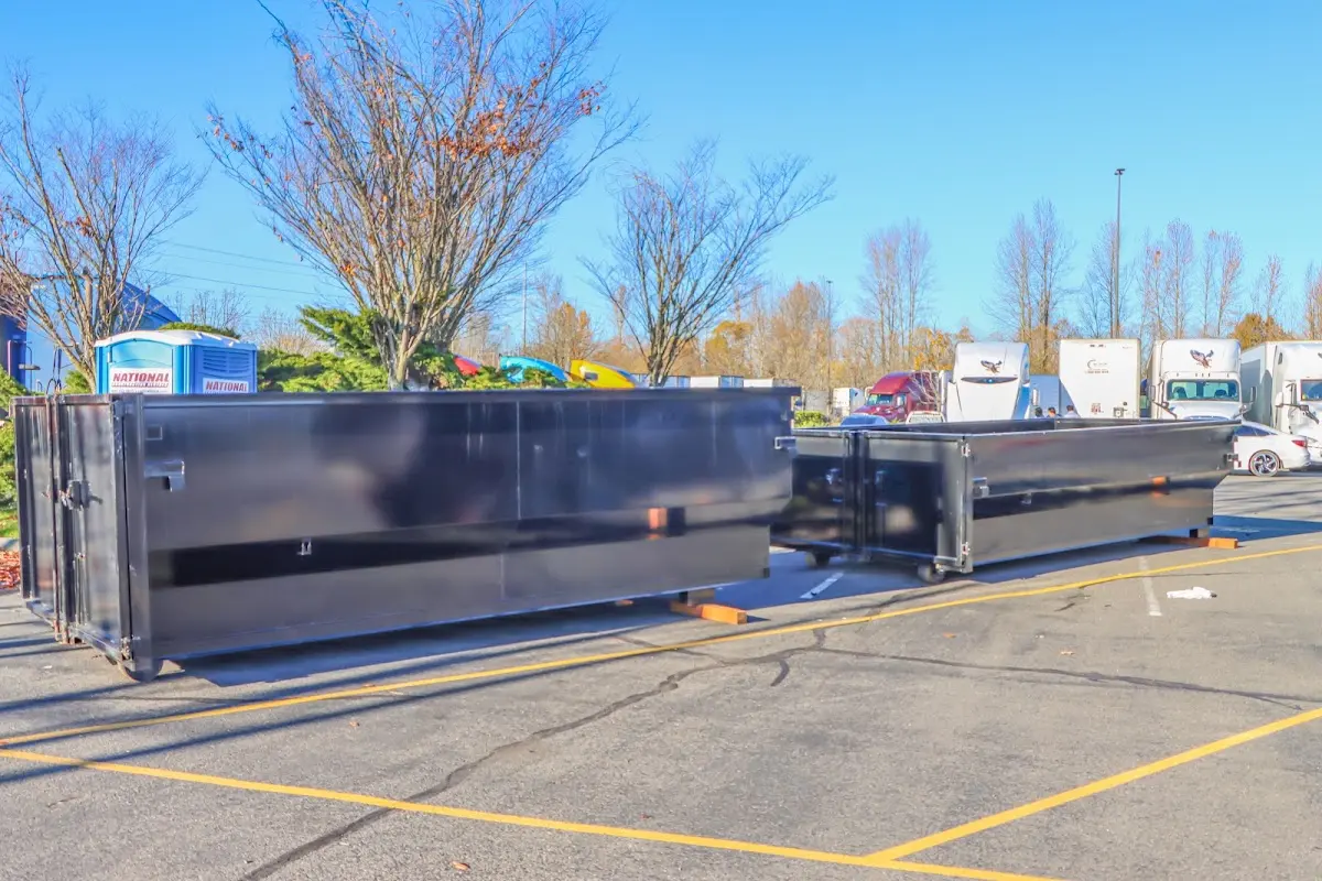 Professional dumpster rental service with roll-off container on residential driveway in Hermon